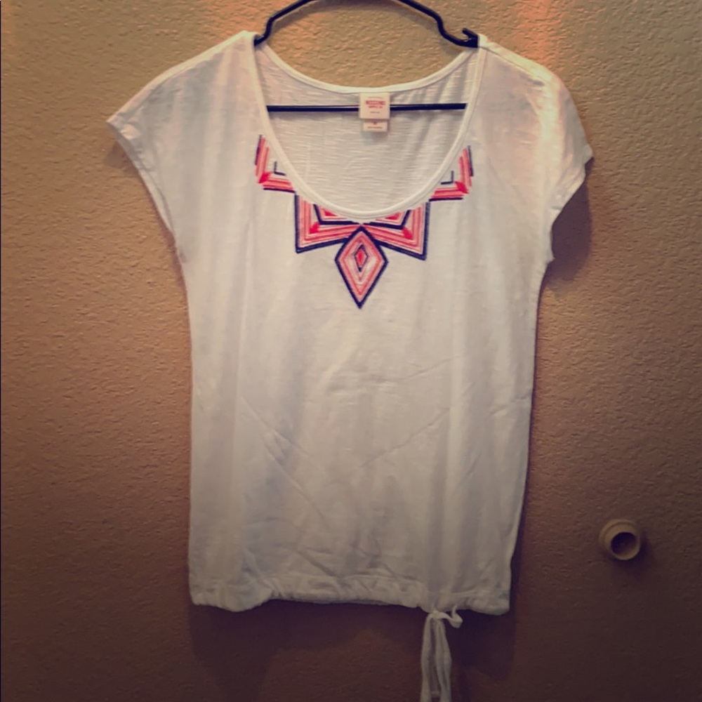 White top with red and blue stitched embellishment